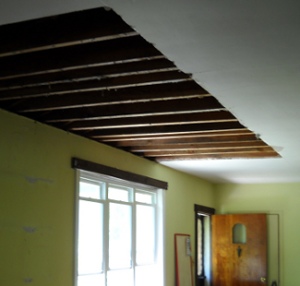 the damaged ceiling torn out in a big, clean opening, showing the rafters