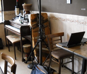 the dulci leaning against the piano inside the Epicure cafe, my stuff on a table by it