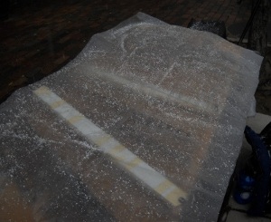dulcimer covered with a piece of clear plastic, covered in snow and sleet