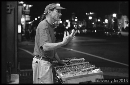 Brian performing on King Street at night, a black and white photo by David Snyder